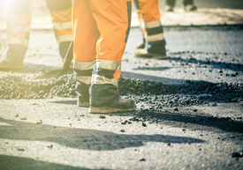 Skupina ľudí v oranžovom a bielom pracovnom oblečení