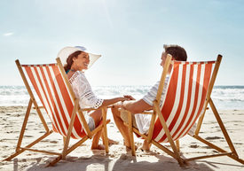 Egy férfi és egy nő ül a strandon a székeken