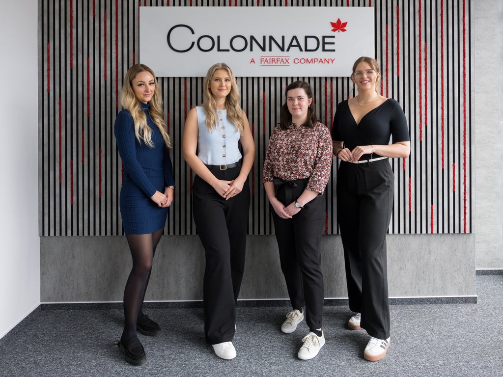 Skupina žien stojacich pred nápisom