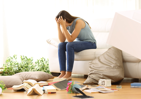 Žena sediaca na pohovke s rukami v tvári