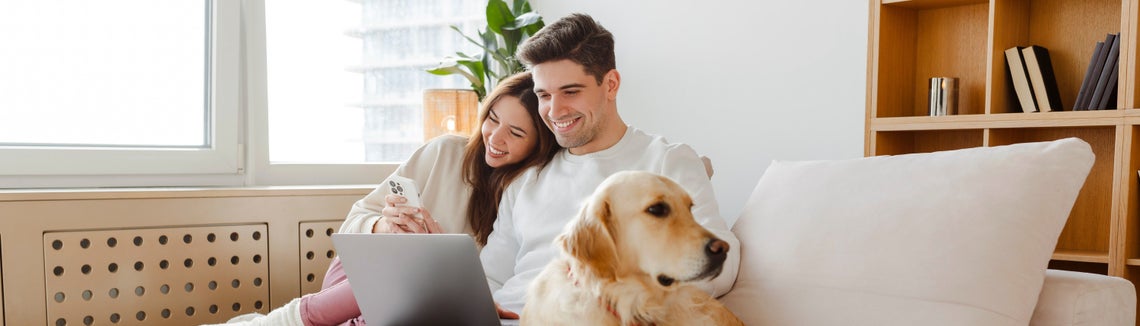 Muž a žena sedící na pohovce se psem