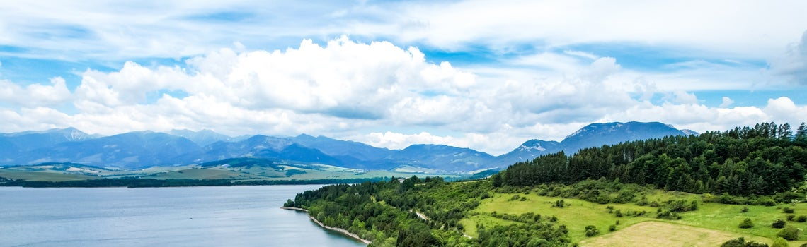 Jazero so stromami a horami v pozadí