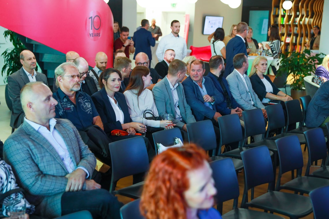 Skupina ľudí sediacich na stoličkách