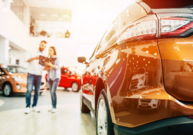 Un bărbat și o femeie se uită la o mașină