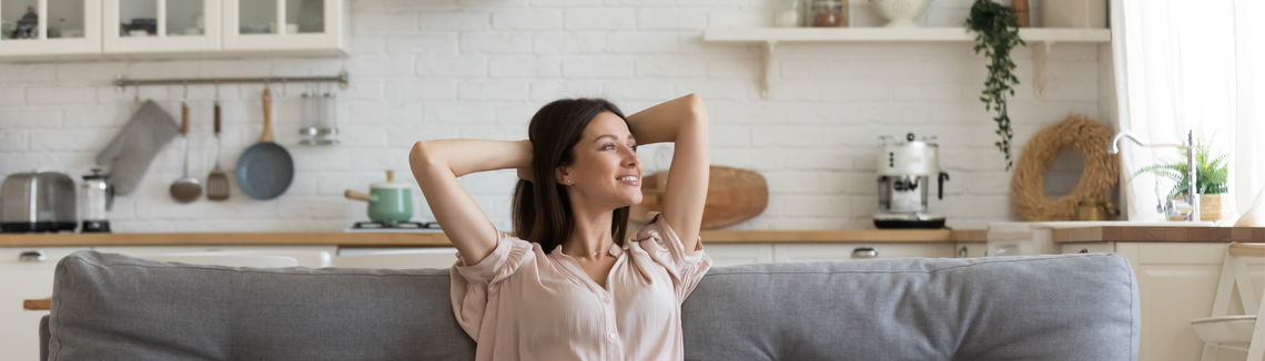 Žena sediaca na pohovke s rukami za hlavou