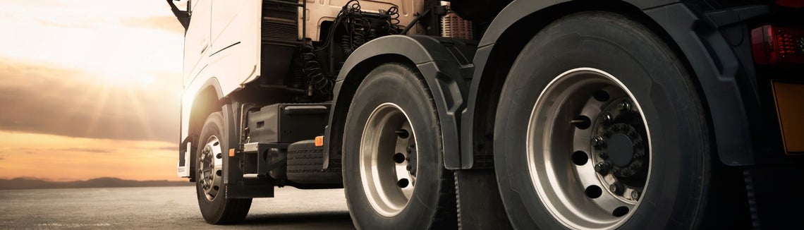 Samochód ciężarowy z pomarańczową naczepą, błysk słońca