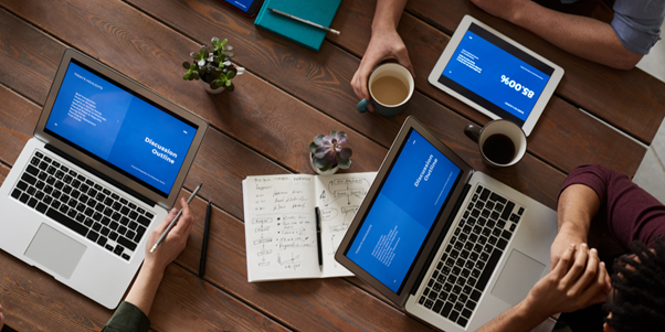 Un grup de persoane care utilizează laptopuri și tablete