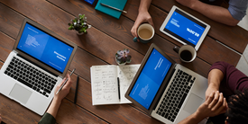 Un grup de persoane care utilizează laptopuri și tablete