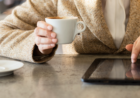 O persoană care ține în mână o ceașcă de cafea