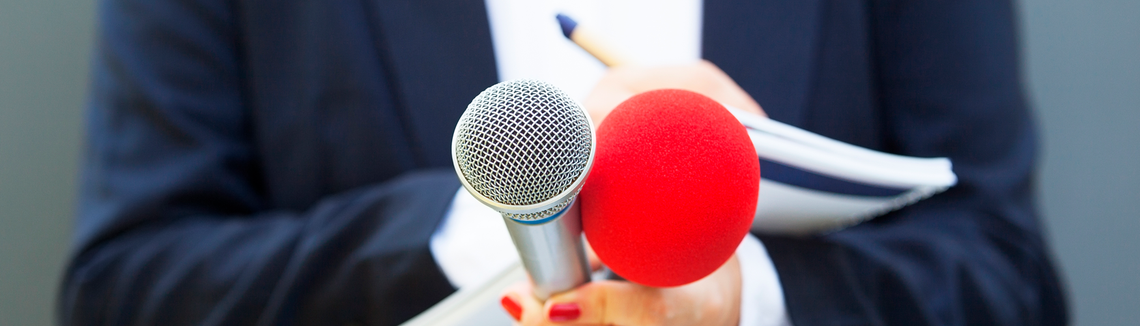 Reportérka s mikrofonem a poznámkami v ruce