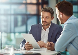 Dvojice mužů, kteří se dívají na tablet