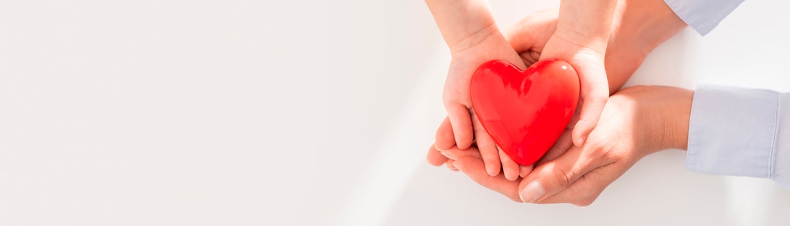 Ruce držící červené srdce