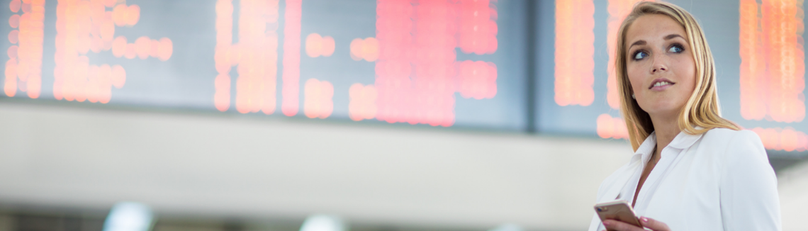 Egy nő, kezében táskával és telefonnal