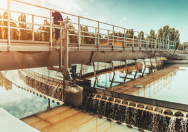 A man standing on a bridge over a river
