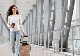 Kobieta trzymająca walizkę i paszport