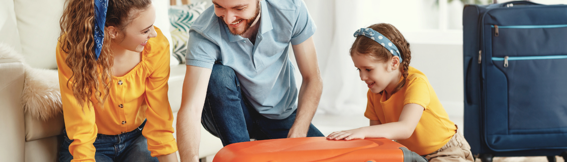 rodzina pakuje walizkę na wyjazd turystyczny, zdjęcie w poziomie, rodzice z córką