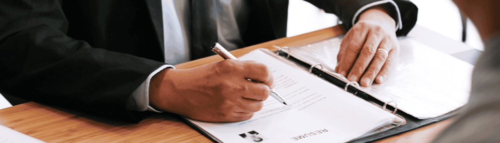 Ręka trzymająca pióro nad papierem