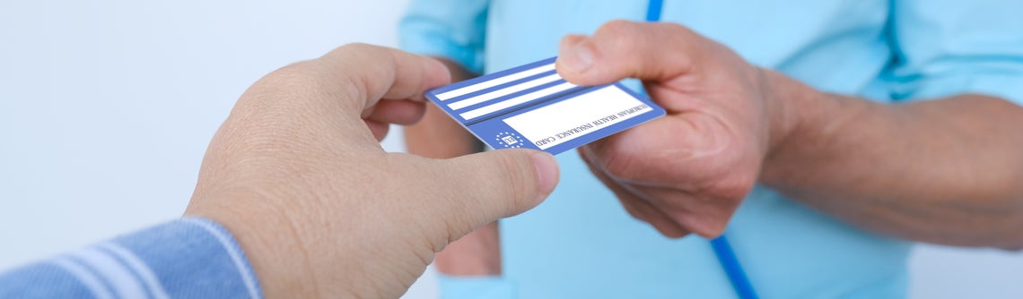 Ръка подава на лекар здравна карта.