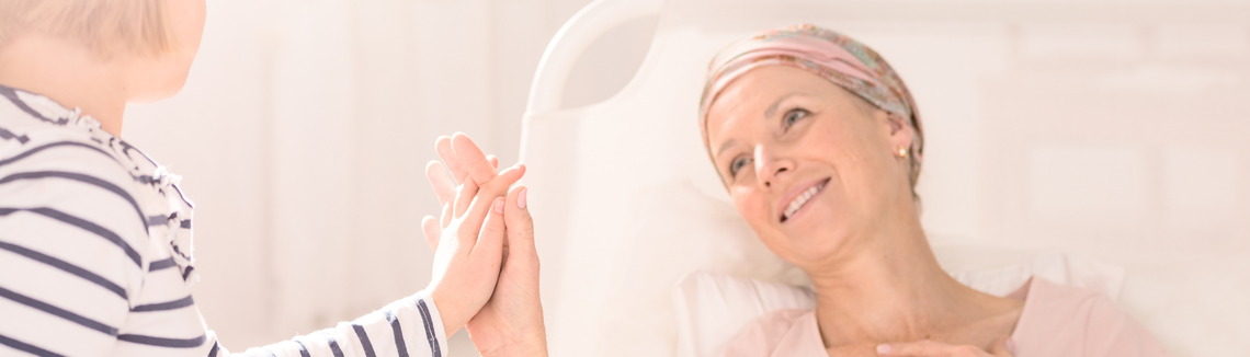 Kobieta w szpitalnym łóżku trzymająca się za ręce