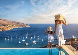 Egy nő és egy gyermek áll a medence mellett, amely egy vízfelületre néz