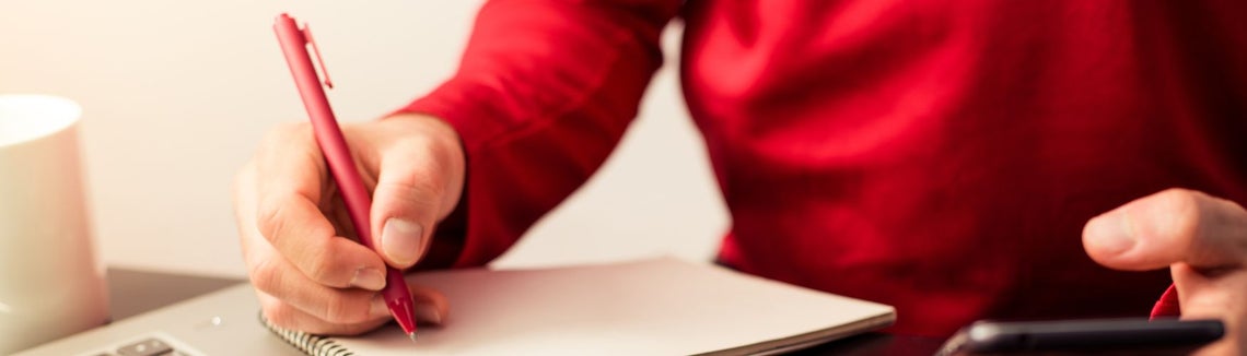 Egy személy tollat tart a kezében