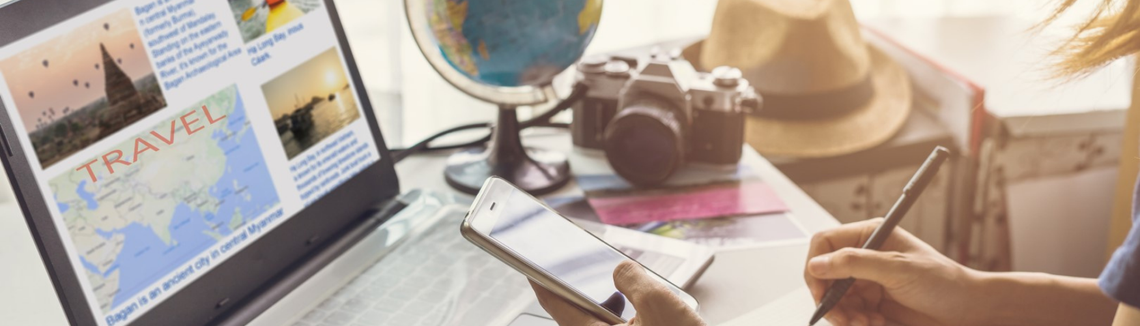 Egy személy, aki egy telefont tart a kezében és egy notebookra ír.