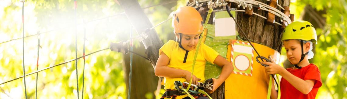 Dziecko noszące kask i sprzęt wspinaczkowy