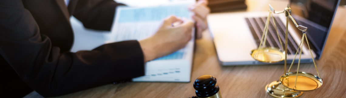 O mână care ține un stilou pe o carte