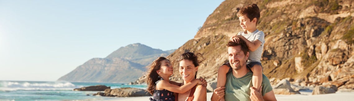 Rodzina spacerująca po plaży na wakacjach