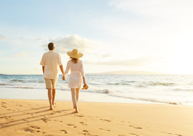 Pár kráčajúci po pláži