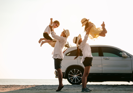 Skupina ľudí na pláži s autom