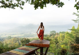 Žena stojící na plošině se stromy v pozadí