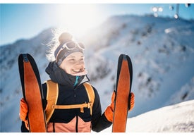 Kobieta trzymająca narty na śniegu