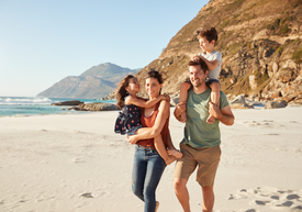 Rodina na pláži s horami v pozadí