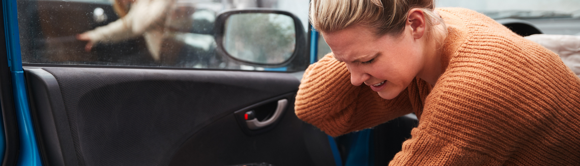 Žena vystupující z auta po nehodě