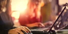 Közelkép egy laptopon gépelő nőről