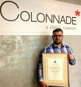 Egy férfi kezében egy bekeretezett oklevél