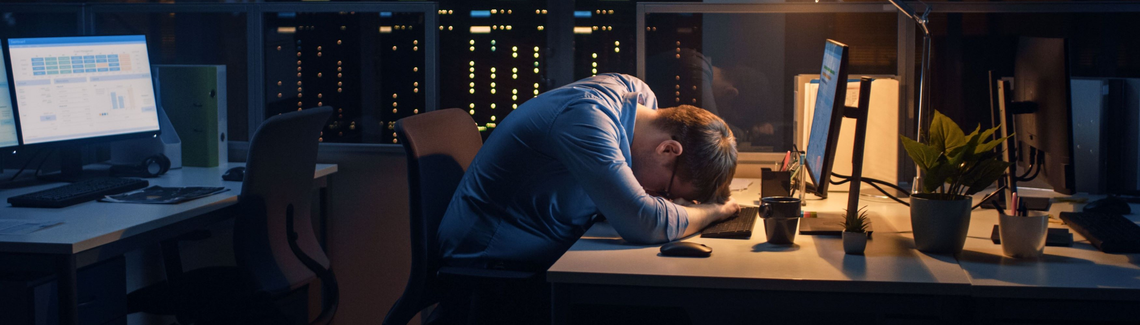 Muž s hlavou na stole v kanceláři