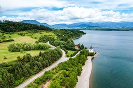 Cesta vedúca k vodnej ploche s bielou budovou a stromami