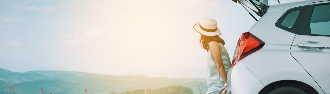 Žena sedí na kopci a pozerá na oblohu