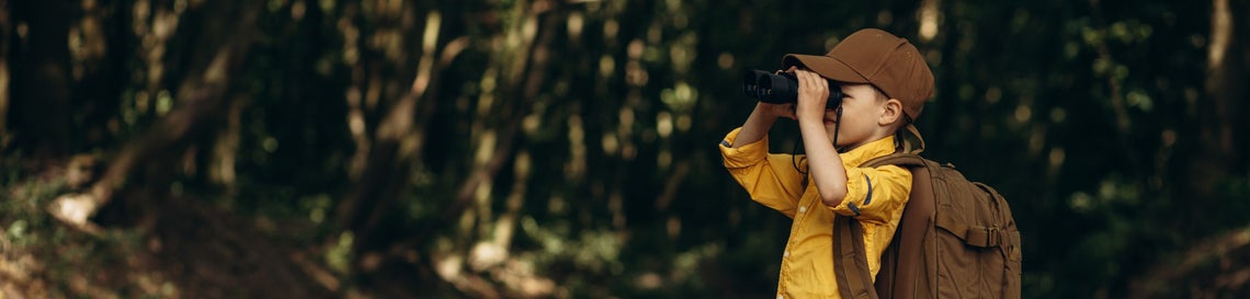 Dítě s dalekohledem v přírodě