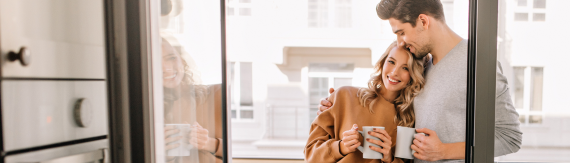 Egy nő megöleli a férjét az erkélyen