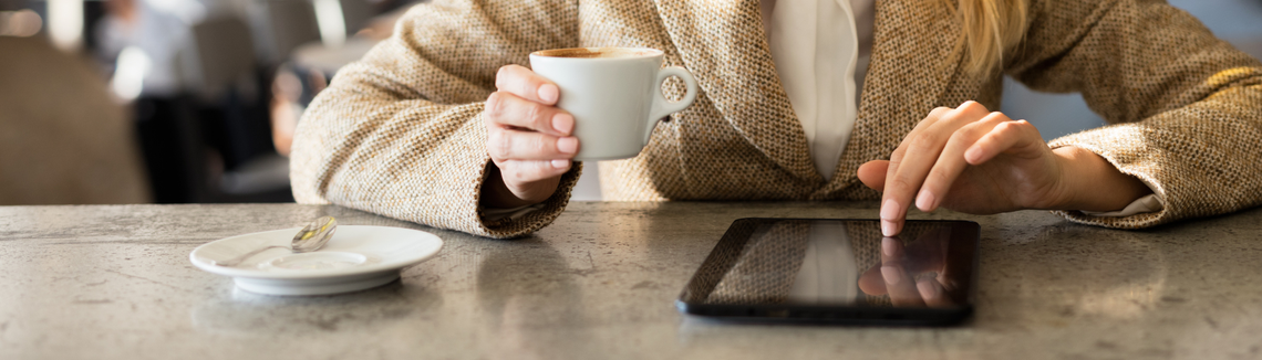 O persoană care ține în mână o ceașcă de cafea