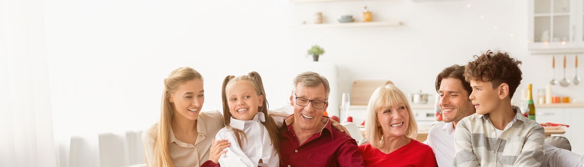 Rodina rodičů, prarodičů a dětí sedících na gauči