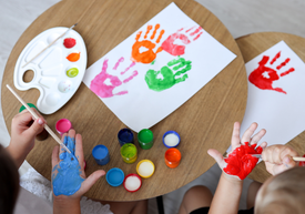 Gyermekek egy csoportja festékkel a kezükre festve