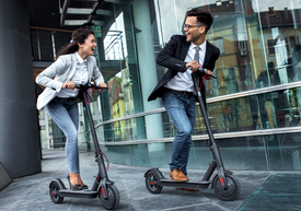 Un bărbat și o femeie care conduc scutere