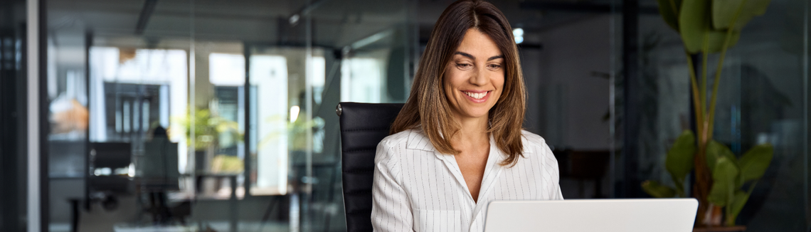Egy nő mosolyog egy laptop előtt