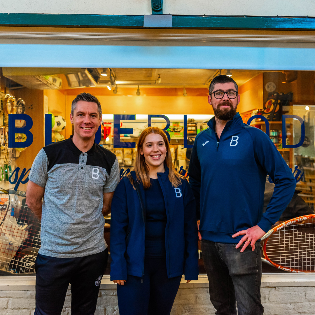 photo of three people standing outside the shop 