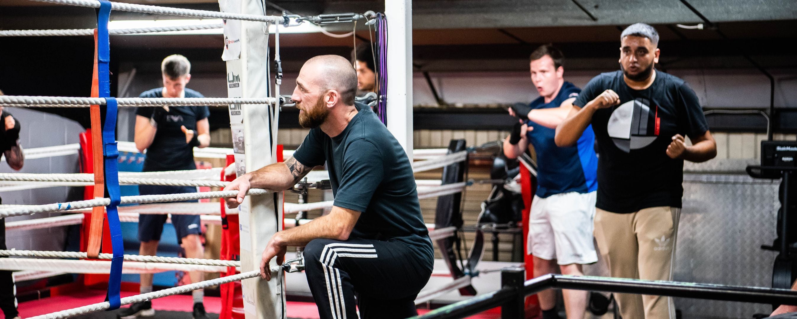 men in boxing gym with coach 