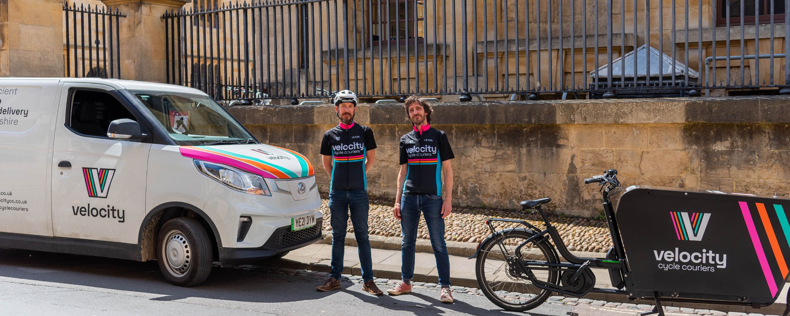 velocity cycle couriers staff stood in front of electric van and bike 